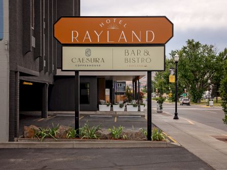 A storefront sign reads &ldquo;HOTEL RAYLAND,&rdquo; featuring C&aelig;sura Coffeehouse and Bar & Bistro at Rayland.